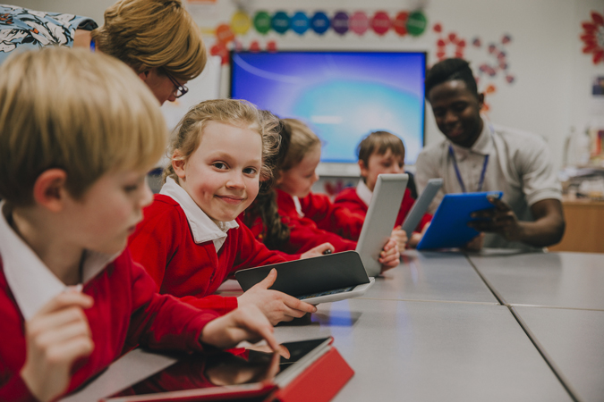 Children in school using tablets